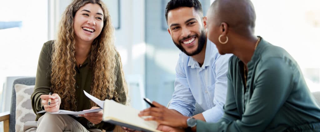Three diverse people sitting and chatting together.