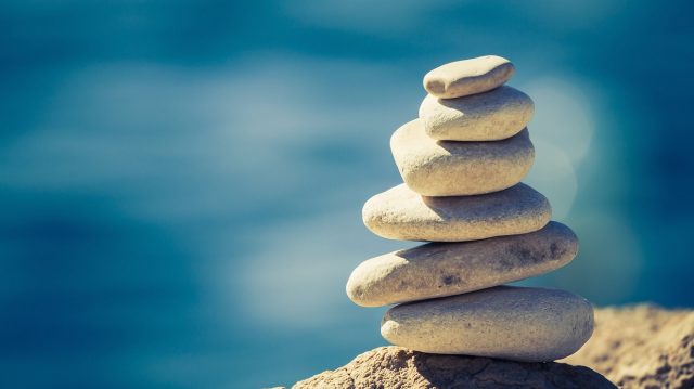 Balance and wellness retro spa concept inspiration zen-like and well being tranquil composition. Close-up of white pebbles stack over blue sea