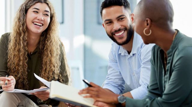 Three diverse people sitting and chatting together.